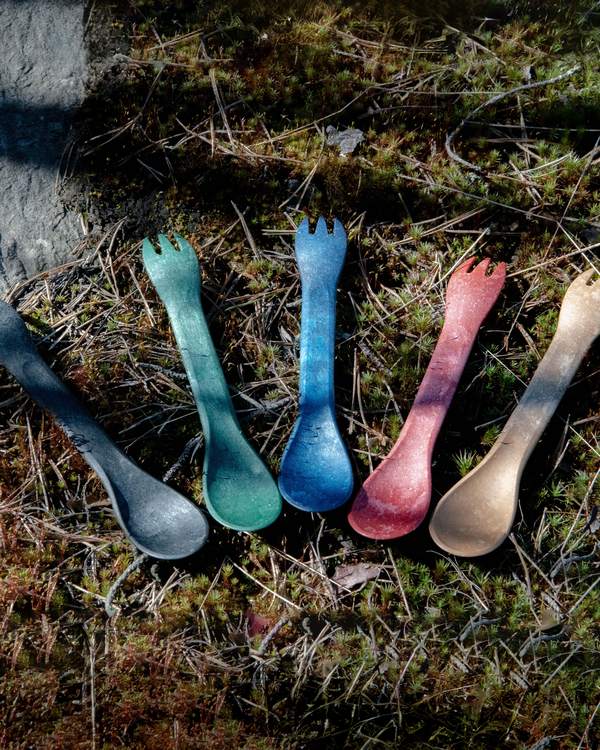 Cinco sporks Kupilka de colores sobre el pasto